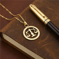 Collier balance dorée sur livre en cuir