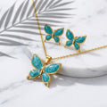 Parure papillon or et émail turquoise - collier pendentif et boucles d'oreilles sur marbre blanc avec feuille de palmier
